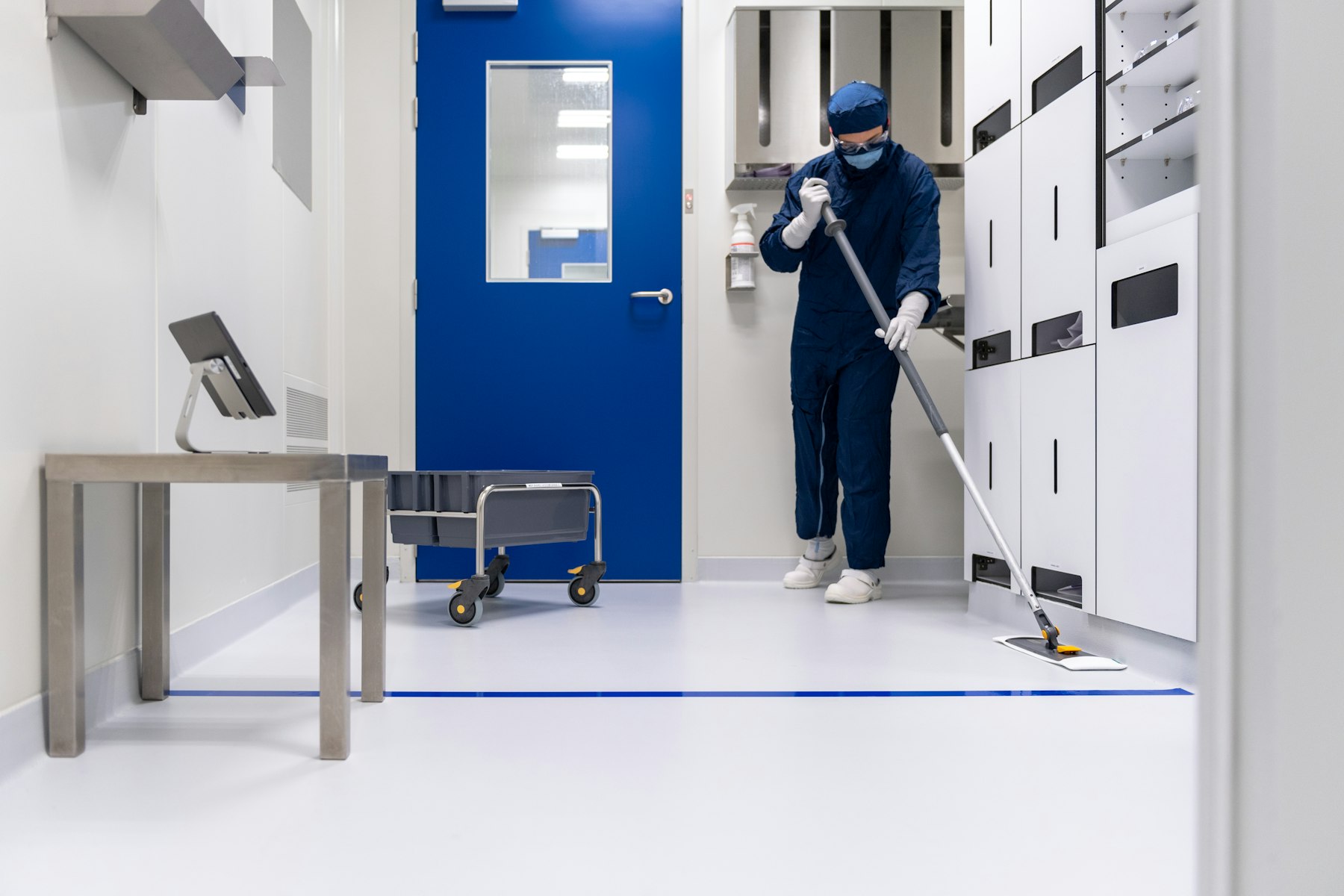 A cleaner mopping a bright commercial corridor