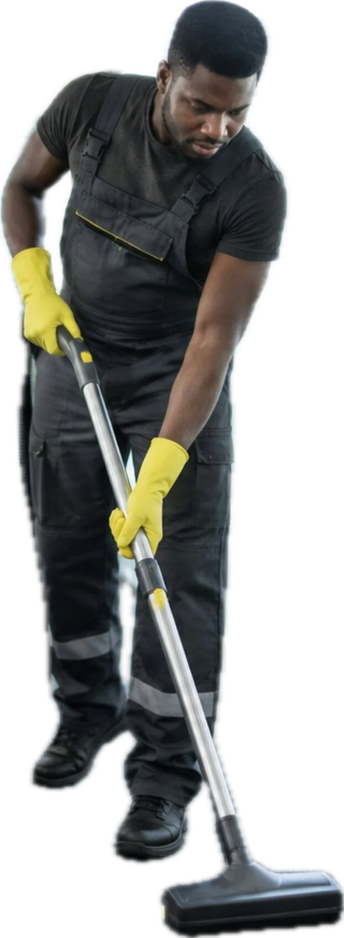 A cleaner in work overalls and yellow gloves vacuuming the floor